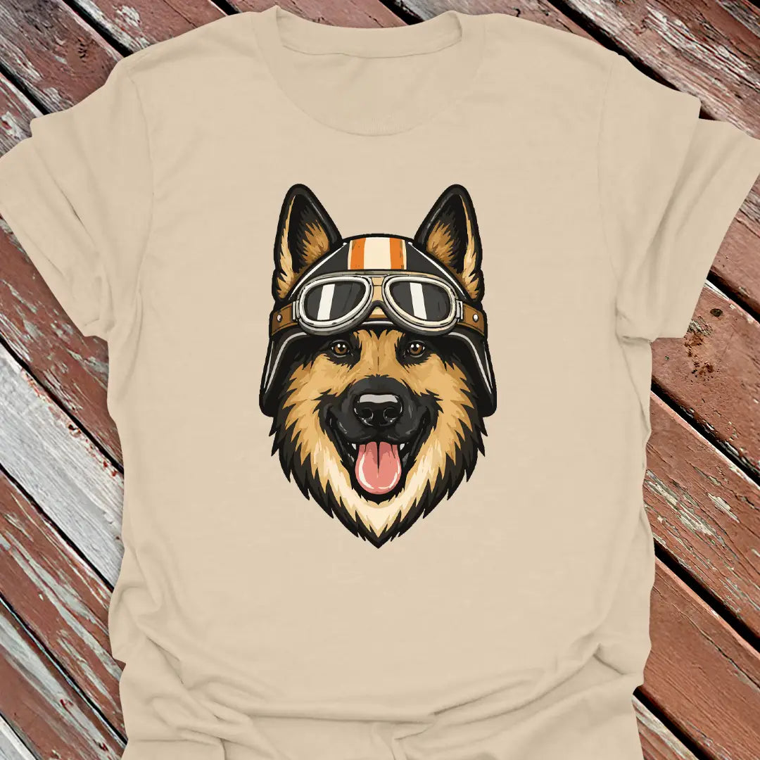Sand color t-shirt with a German Shepherd dog wearing a helmet and goggles on a wooden surface