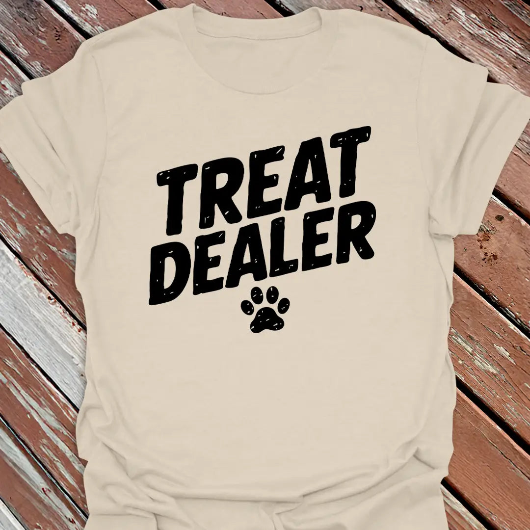 Beige t-shirt with 'Treat Dealer' text and paw print on a wooden surface