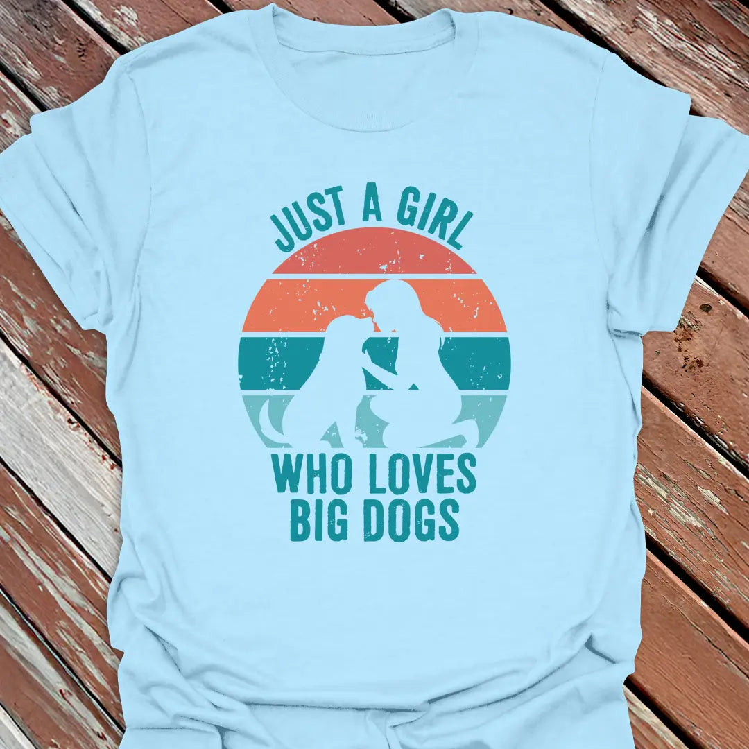 Light blue t-shirt with Just a Girl who loves big dogs design on a wooden surface
