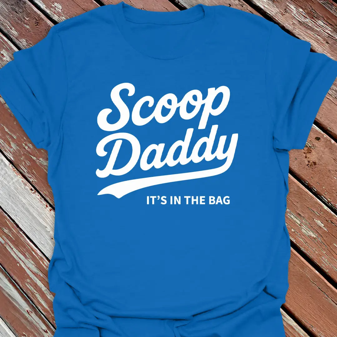 Big Woofer Wear royal “Scoop Daddy” T-shirt for big dog dads, bold scoop and paw design on wood background
